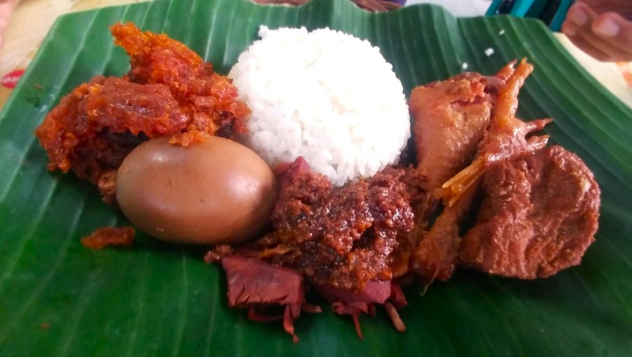 Nasi Padang di atas daun pisang dengan aneka lauk dan telur balado
